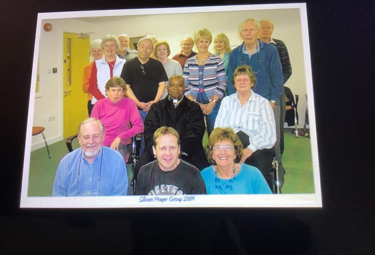 A diverse local community prayer group posing for a group portrait indoors in 2001.