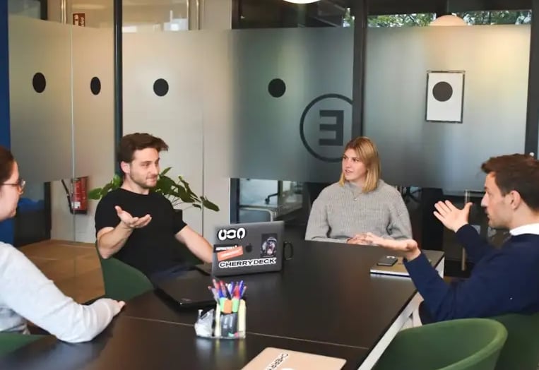 Team meeting with diverse professionals discussing marketing strategies around a table.