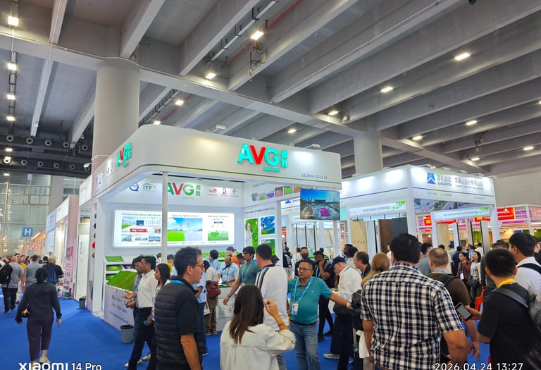 Crowded AVG artificial grass booth at a busy international trade show exhibition hall.