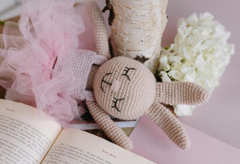 Amigurumi de coneja de crochet con tutu rosa y fondo color rosa