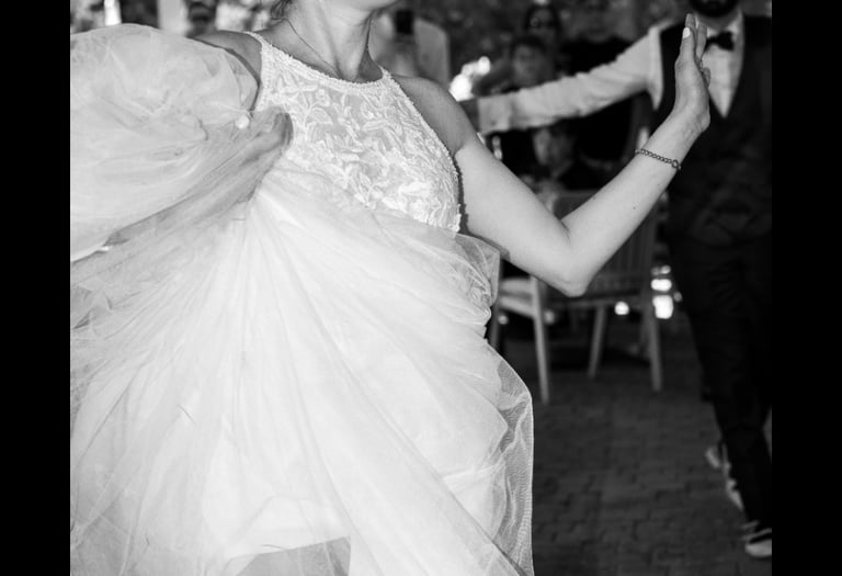a woman in a wedding dress dancing with a man in a suit
