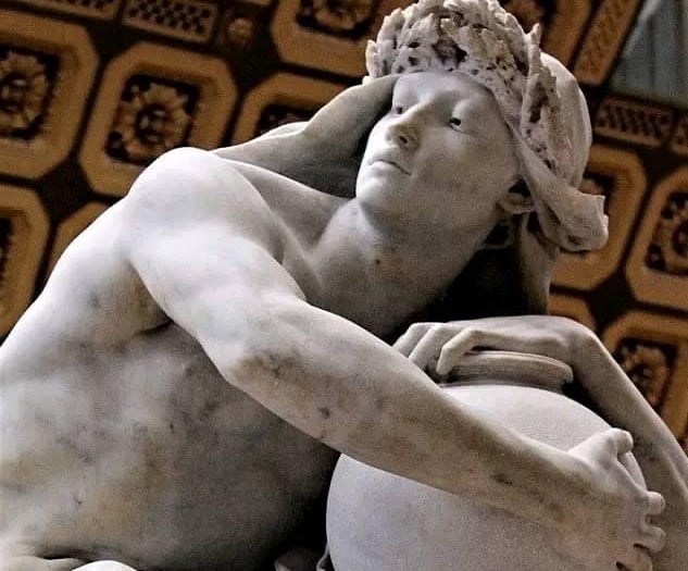 Classical marble sculpture of a man wearing a laurel wreath and holding a large vessel.