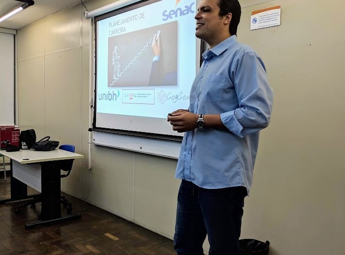 Um homem em frente a uma apresentação sobre carreira palestrando para uma platéia