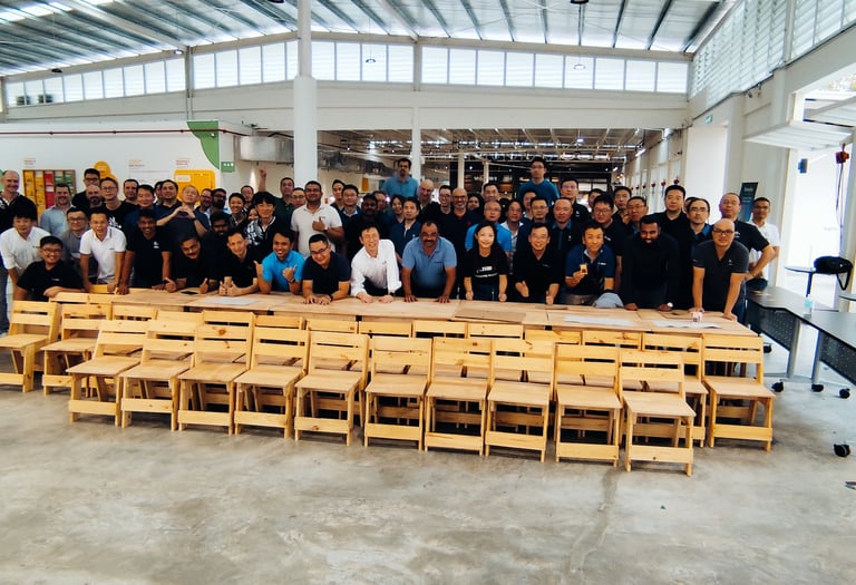 Participants posing for photos after completed making classroom chairs and tables