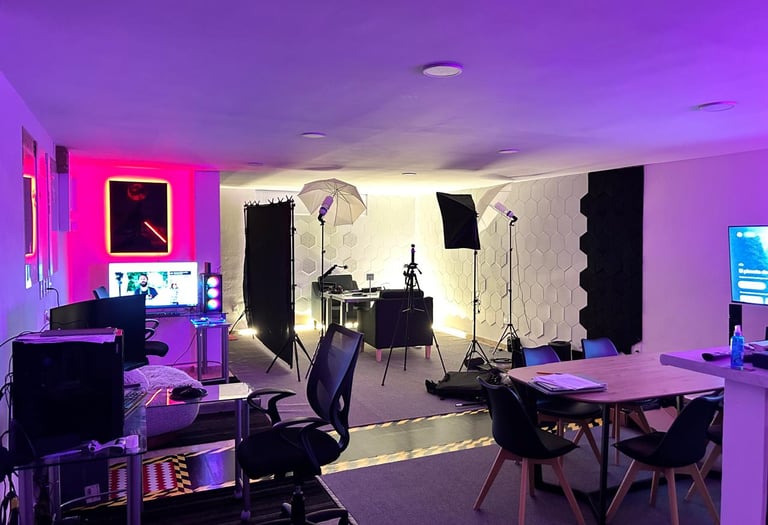 Professional podcast and video production studio with purple LED lighting, softboxes, and acoustic wall panels.