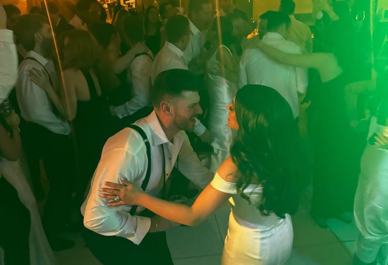 Bride and groom dancing to LuxeBand at their wedding with guests on the dance floor