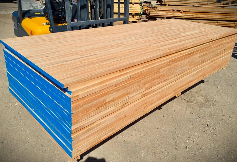 Una pila de láminas de madera contrachapada industrial con los bordes pintados de azul.