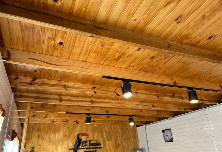 Interior rústico con techo de vigas de madera a la vista e iluminación moderna.