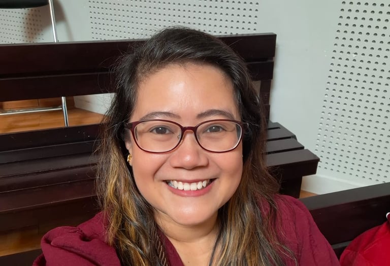 a woman in a red shirt and glasses sitting at a table