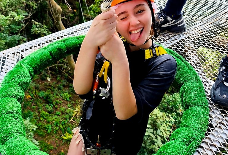 a woman in a helmet and helmet on a rope - zipline adventure park koh samui