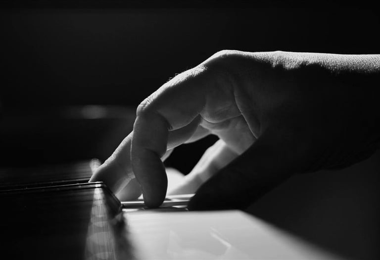 a person's hand is touching the keyboard of a piano