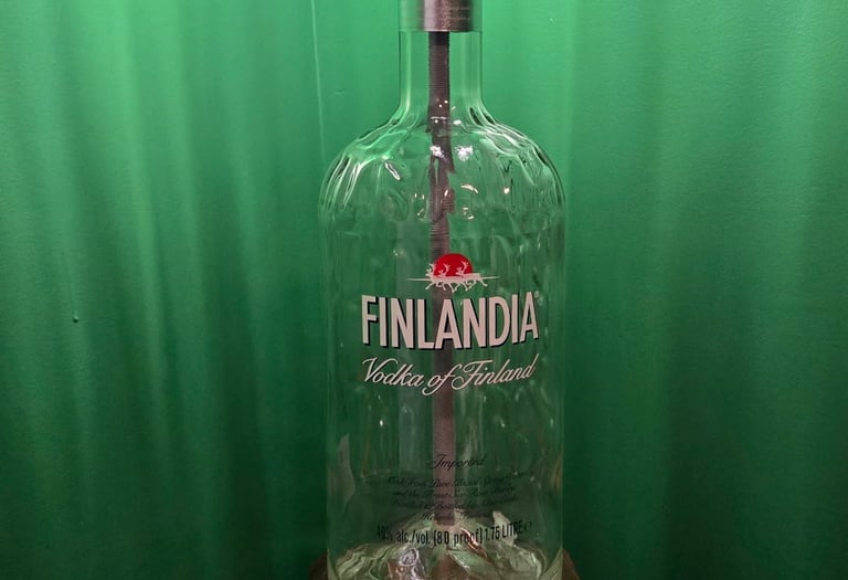 Custom industrial table lamp made from a Finlandia Vodka bottle on a rustic wood base.