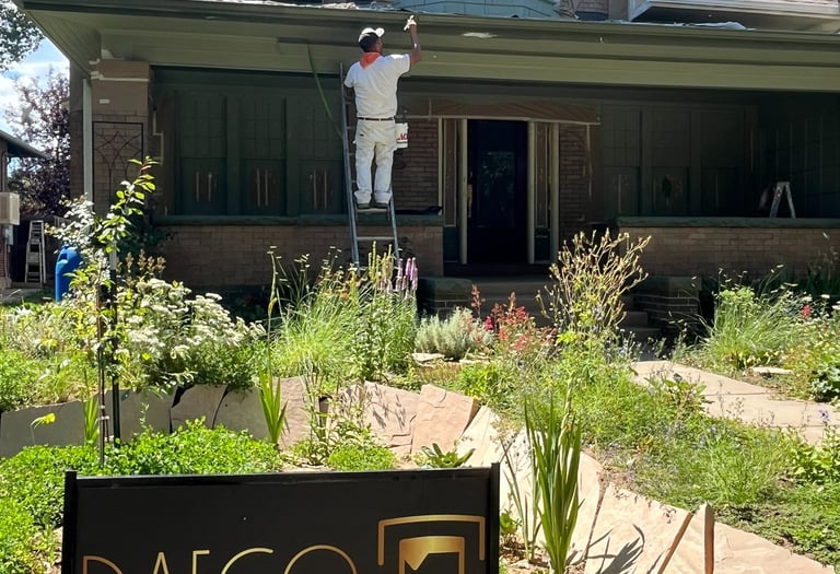 a man painting a house with a sign that says daceo
