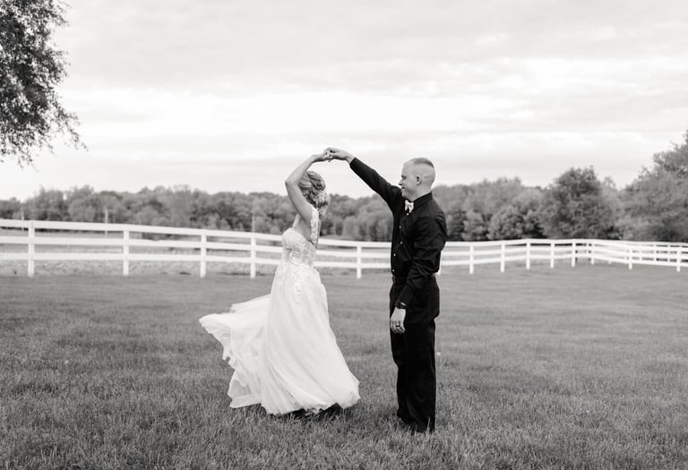 a bride and groom dancing in a field