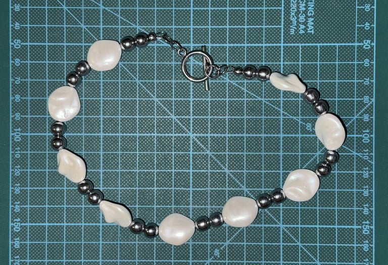 Unisex necklace with irregular pearl masses and polished hematite beads, styled with a toggle clasp