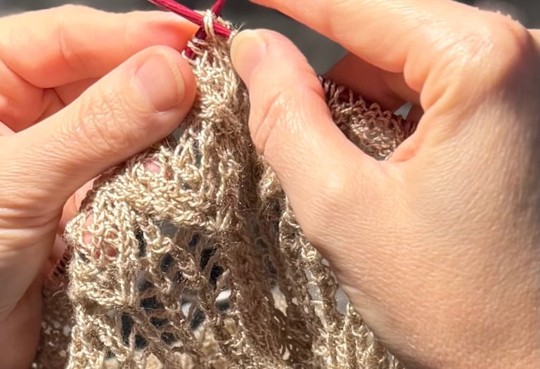 A close-up image of a pair of hands working a stitch