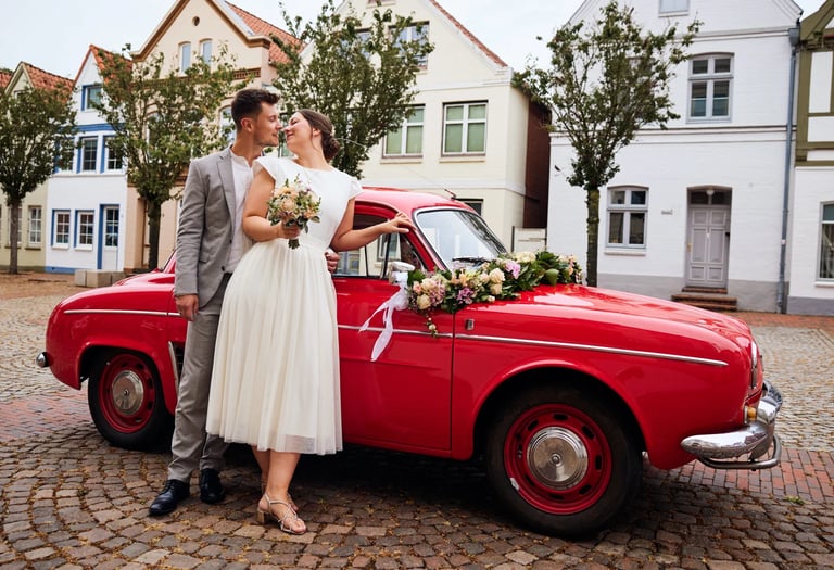 Close-up of a pink rose boutonniere on a groom's navy blue wedding suit jacket.