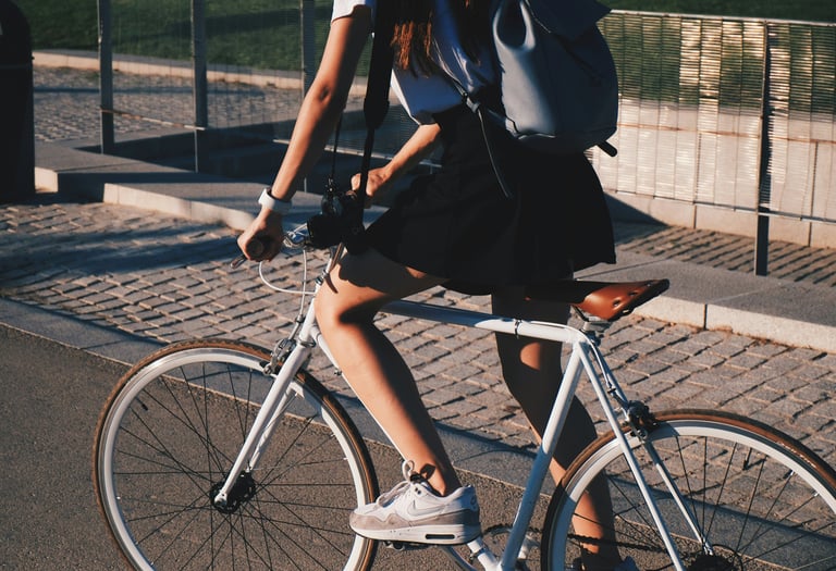 a woman riding a bicycle with a backpack on it