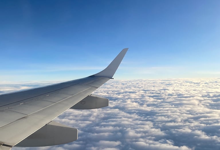 a view of a wing of a plane above the clouds