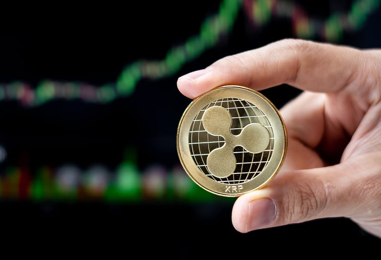 ripple xrp token in someones hands with charts in background