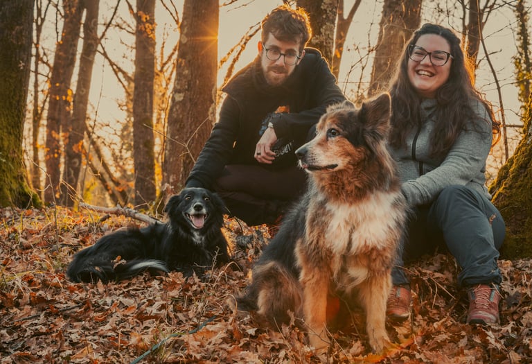 famiglia di due persone che sorridono con due cani al tramonto