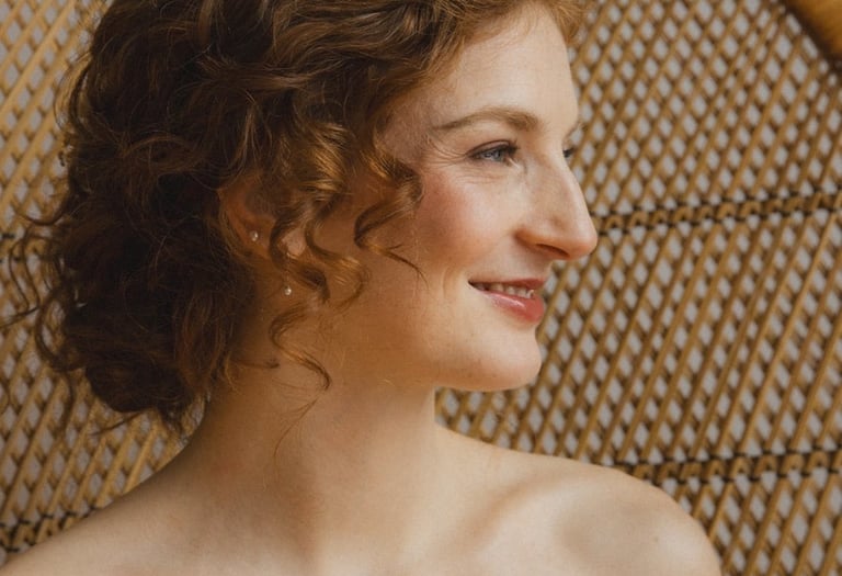 Une mariée rousse heureuse regarde vers l'extérieur.