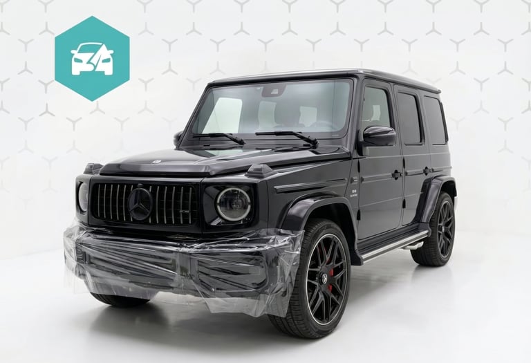 Black Mercedes-Benz G-Class SUV with paint protection film on the front bumper in a studio.