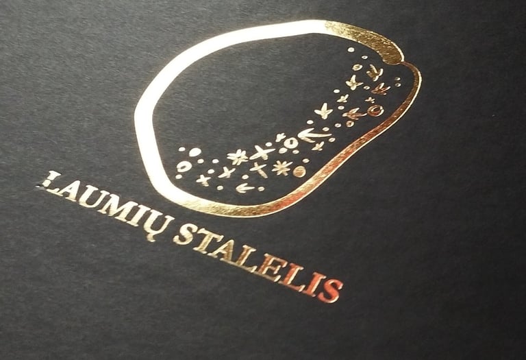 Luxury black matte gift box featuring a gold foil Laumių Stalelis logo with celestial star patterns.
