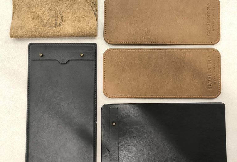 Handcrafted leather and suede menu covers and bill folders in black and tan for restaurant tabletop accessories.
