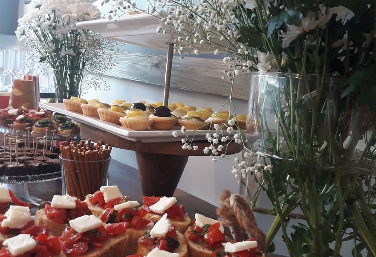 üzerinde kanepe, petifür (petit four), kraker ve tartolet bulunan masa