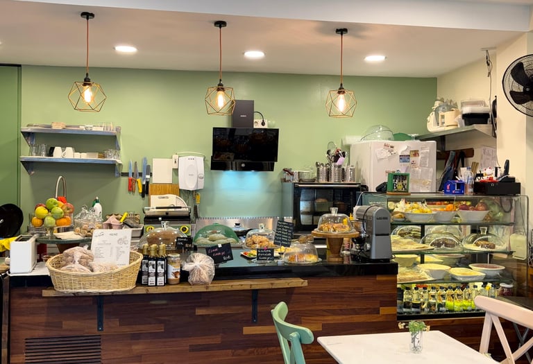 tezgahın üzerinde çay, yiecek içecekler ve sunum dolabı olan bir cafe tezgahı