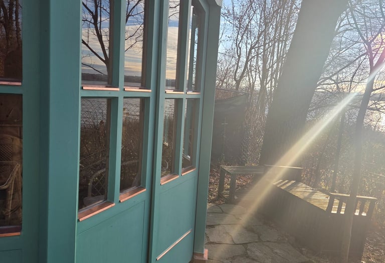 Grüner Holzpavillon mit verglasten Flügeltüren und Kupferdetails am Ufer des Ammersees von Holztechnik Volk