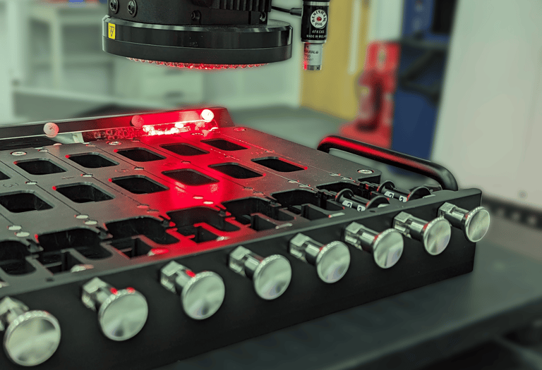 Multi-nest metrology fixture holding small thin medical devices whilst being inspected by an optical CMM.