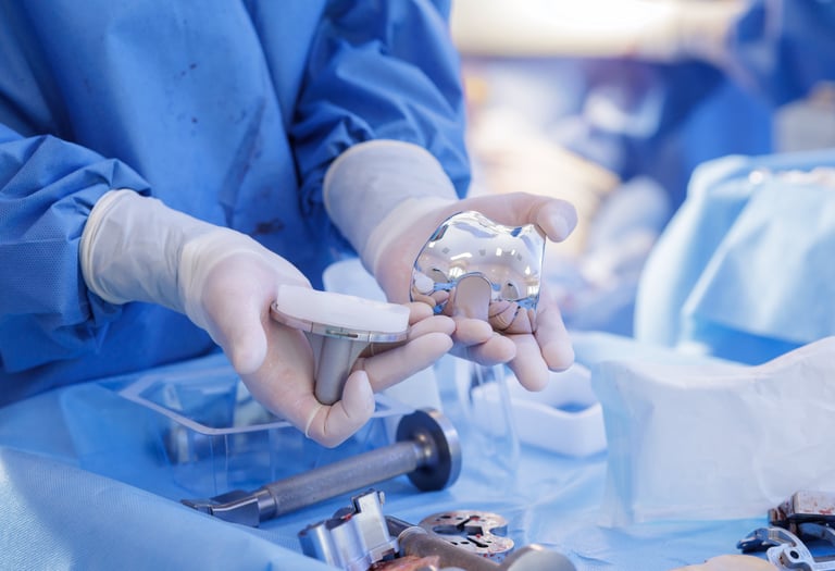 medical technical inspecting a set of orthopedic knee implants.