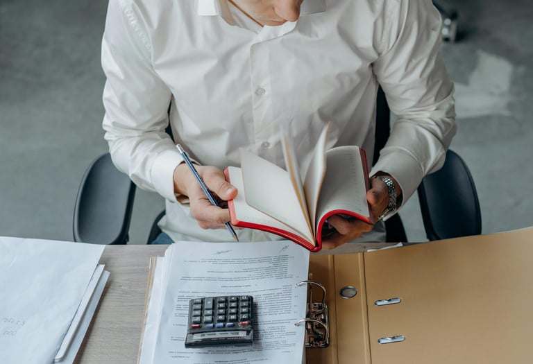 Mężczyzna pracujący z dokumentami w biurze, jako dopełnienie nagłówka Biura Rachunkowego Deltaxing.
