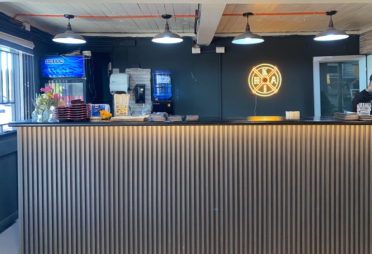 Diseño de barra de sushi listonada con iluminación técnica por Atípico Studio en Santiago.