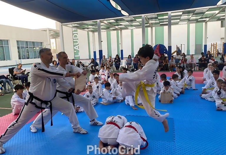 Hwa Rang Taekwon-Do Student with a flying kick breaking boards