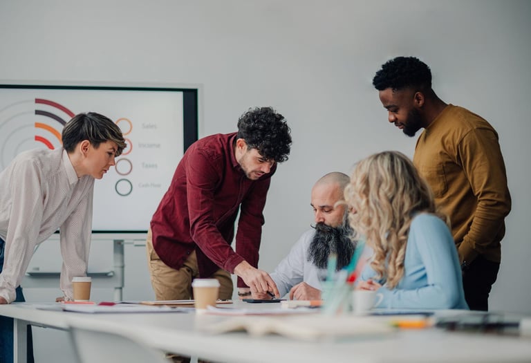 A diverse group of five people engaged in a collaborative meeting around a table