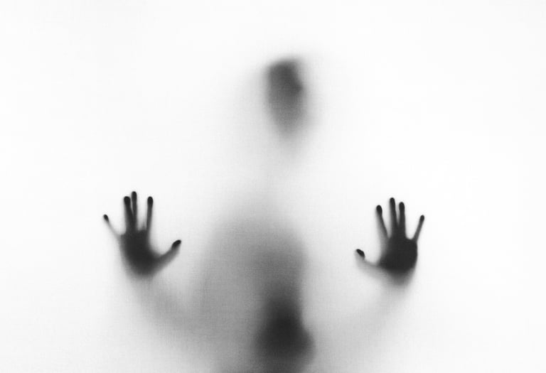Eerie blurry silhouette of a person pressing their hands against a frosted glass surface.