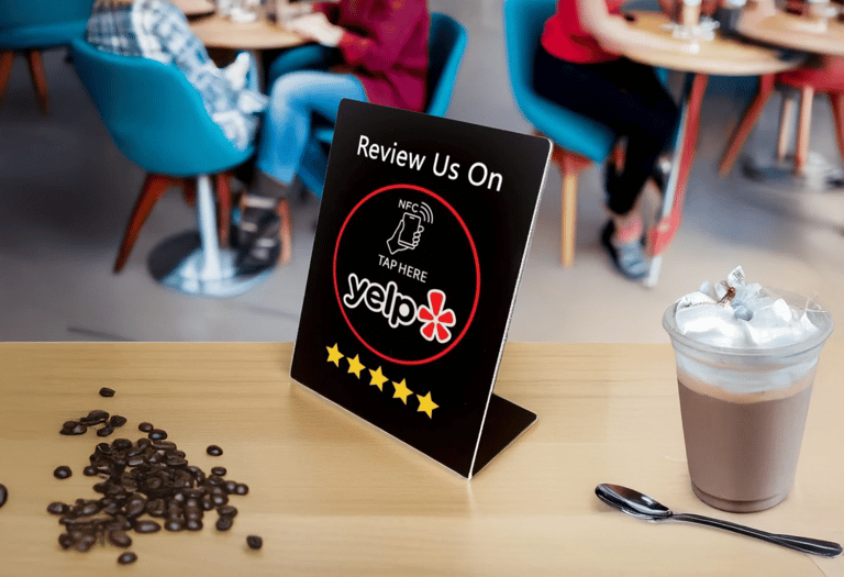 Yelp NFC review sign on cafe counter with coffee and beans. Boost feedback using digital tech.