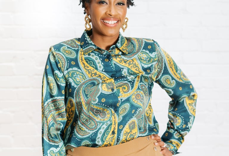 a woman in a blue paisley shirt and tan pants