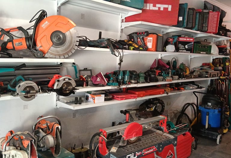 Workshop shelves organized with power tools, circular saws, and construction equipment for professional use.