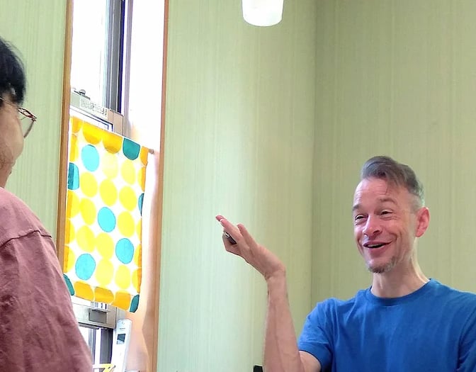 man sitting at table teaching student