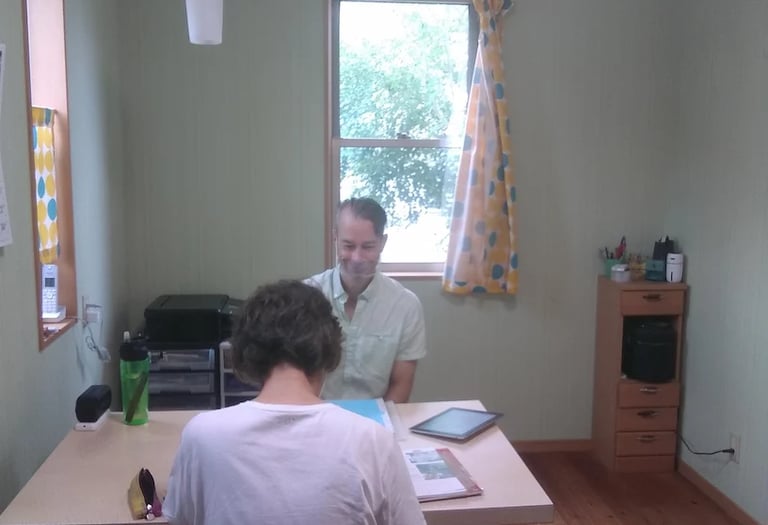 man teaching student at table