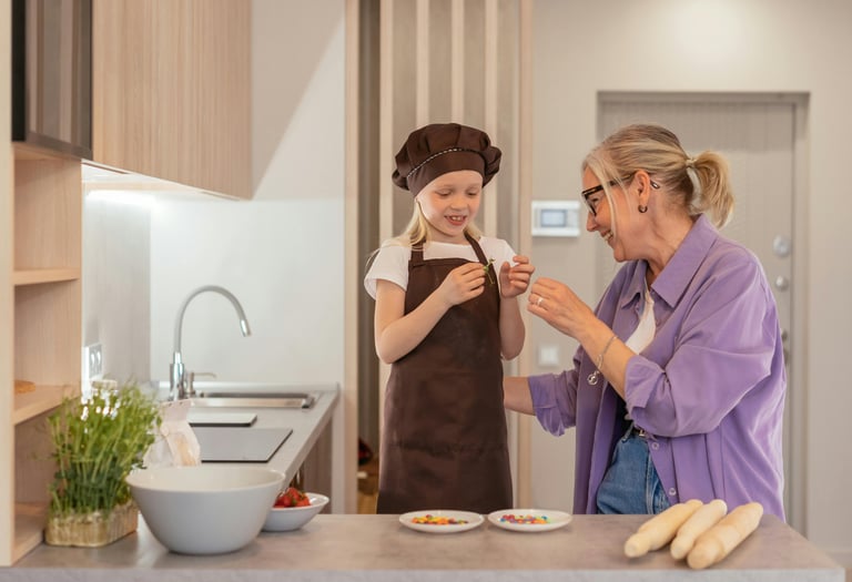 a grandmother standing in her kitchen with a grand daughter preparing food together