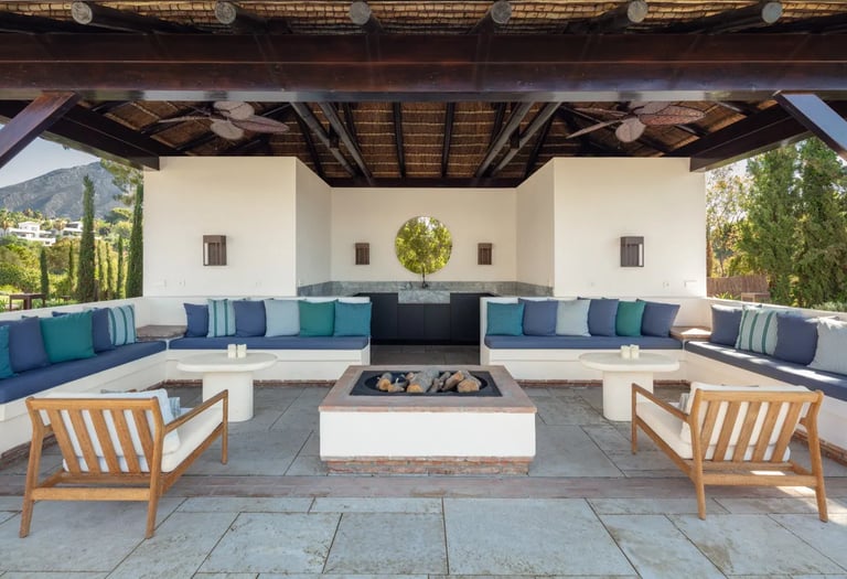 Covered outdoor lounge at Villa La Gratitud with fire pit and pool views