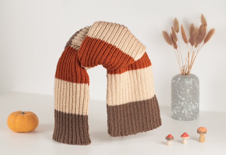 écharpe faite à la main marron, beige et orange sur fon blanc, décor avec citrouille et champignons