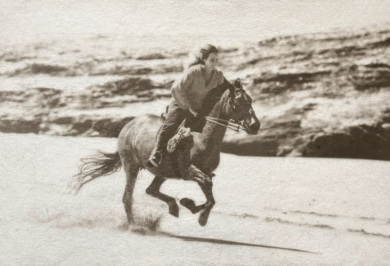 Black and white photograph in silver and Platinum of a woman riding a horse on a beach