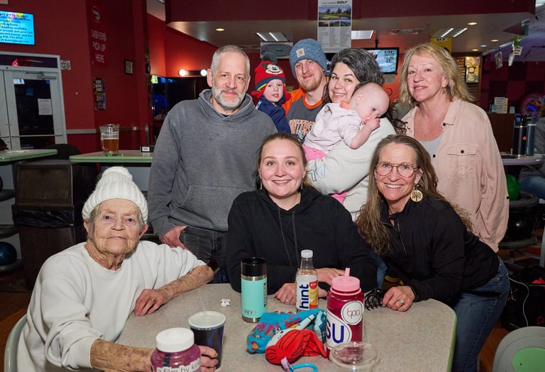 a group of people sitting around a table with a baby