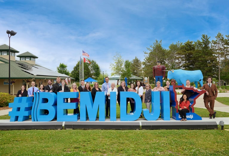 a group of people standing in front of a sign that says bemidji